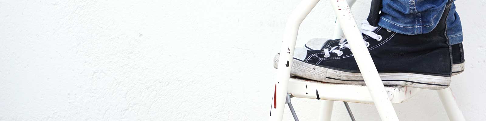 Füsse auf einer Haushaltsleiter mit Plattform